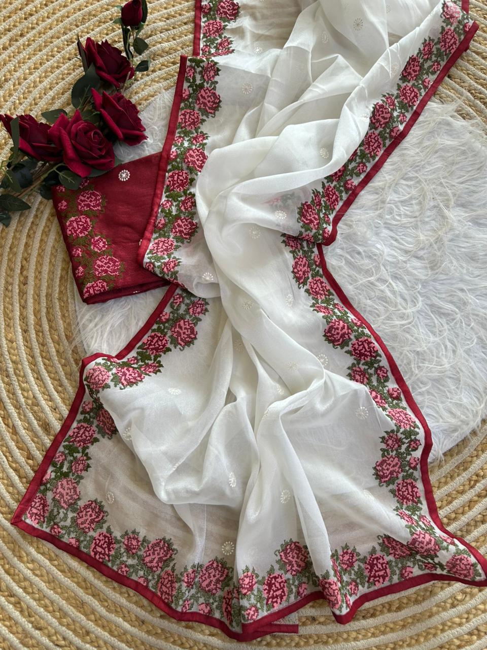 Pure simmer tissue silk saree in a solid pearl white color with cross stich embroidery viscos work in saree Paired with  Raw silk  blouse of maroon color  with work border